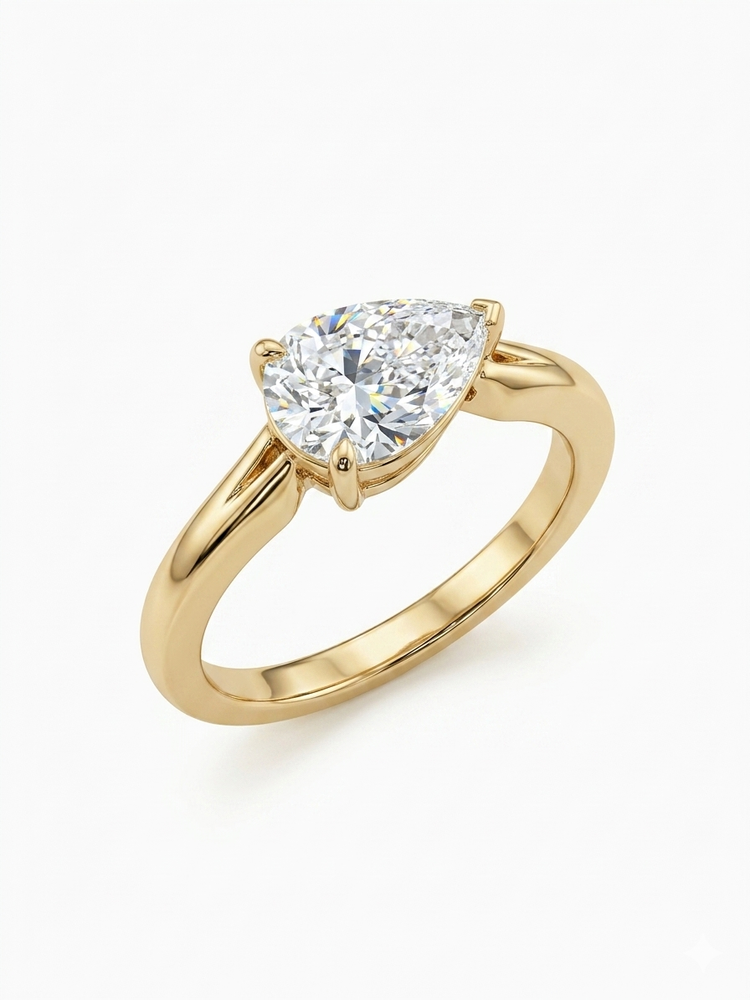Gold ring with a pear-shaped diamond on a white background