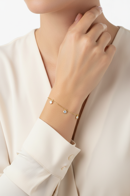 Gold diamond bracelet on woman's wrist with shirt